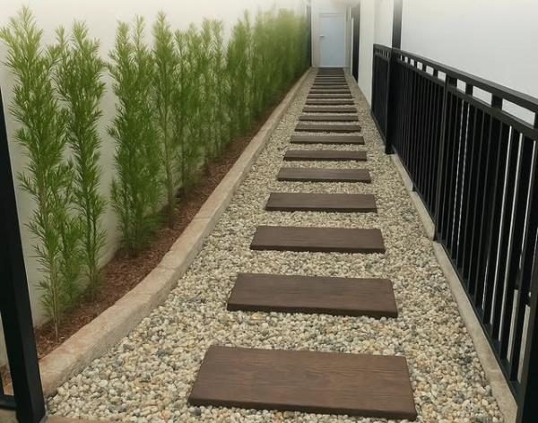 Caminho de jardim com pisantes de concreto linha madeira sobre pedriscos